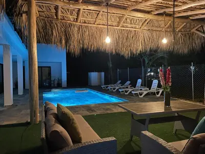 a swimming pool with chairs and a table and a table at Apartamento Entre Playas 1 - 3 pax, 4 min de la playa in Las Galeras