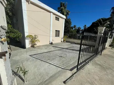 a gate in front of a white building with palm trees at Loft's R&L in Juan de Herrera