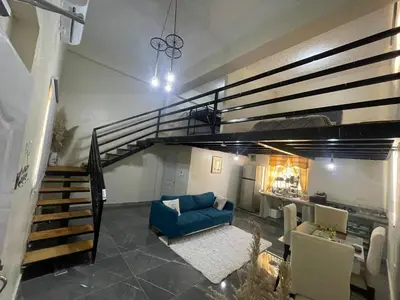 a living room with a staircase and a blue couch at Loft's R&L in Juan de Herrera