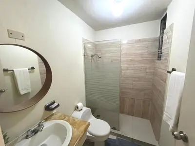 a bathroom with a toilet and a sink and a mirror at A Beautiful Studio Apartments Furnished in Gascue in Santo Domingo
