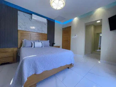 a bedroom with a large bed and a television at Villa VP One - Punta rucia beach in Punta Rucia