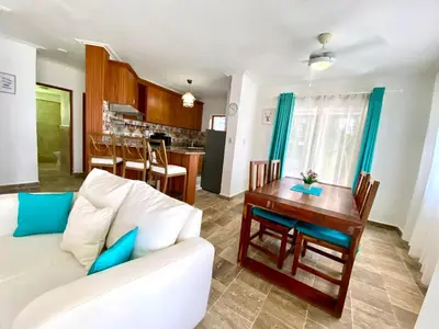 a living room with a white couch and a table at Un Lugar Único y Céntrico RD Los Corales in Punta Cana