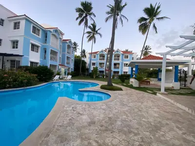 a villa with a swimming pool and palm trees at Un Lugar Único y Céntrico RD Los Corales in Punta Cana
