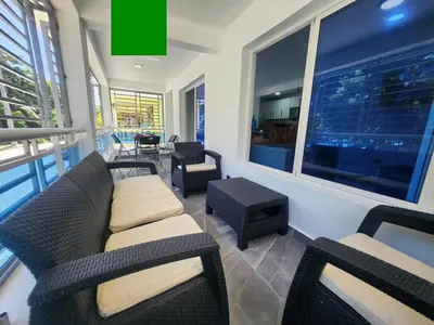 a living room with a couch and chairs and a window at Apartment in front of beach, AC, Wifi, Hot Water in Paraíso