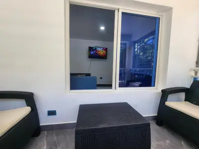 a living room with two chairs and a window at Apartment in front of beach, AC, Wifi, Hot Water in Paraíso