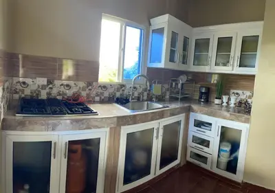 a kitchen with white cabinets and a sink at Casa lopez in Jarabacoa