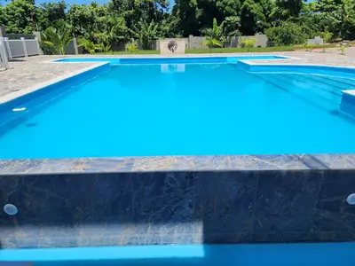a swimming pool with blue water at Bella Villa room with kitchenette, pool and close to the beach in Las Galeras in Las Galeras
