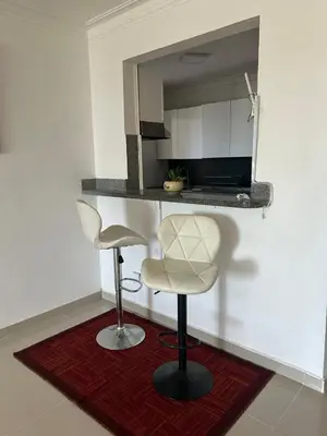 a kitchen with two bar stools and a counter with a microwave at Gran Apartamento frente al mar in La Francia