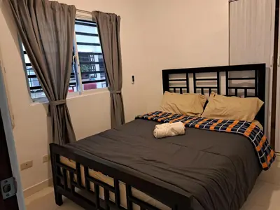 a bedroom with a black bed with a hat on it at Ciudad Juan Bosch StoDgo este in La Javilla