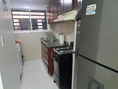a small kitchen with a stove and a refrigerator at Ciudad Juan Bosch StoDgo este in La Javilla