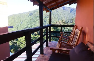 a balcony with two chairs and a view of a mountain at Vista Montaña Jimenoa de la Rosa in Jarabacoa