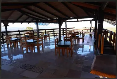 an empty restaurant with wooden tables and chairs at Vista Montaña Jimenoa de la Rosa in Jarabacoa