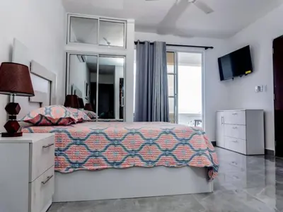 a bedroom with a bed and a dresser and a television at Villas Hillside apt 4 in Santa Bárbara de Samaná