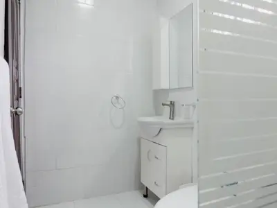 a white bathroom with a sink and a shower at Villas Hillside apt 4 in Santa Bárbara de Samaná