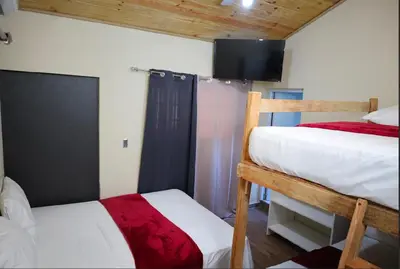 a bedroom with two bunk beds and a flat screen tv at Vista Montaña Jimenoa De La Rosa in Jarabacoa