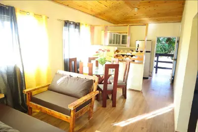 a living room with a table and chairs and a kitchen at Vista Montaña Jimenoa De La Rosa in Jarabacoa