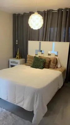 a bedroom with a large white bed with a chandelier at Heaven apart cerca del aeropuerto parqueo incluído TAXI DISPONIBLE in Monte Adentro
