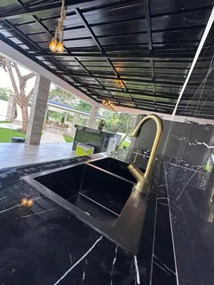 a kitchen with a black counter top with a sink at Villa Canaan in Pedro Brand