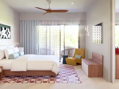 a bedroom with a large white bed and a chair at Fiesta Americana Funeeq Punta Cana All Inclusive in Punta Cana