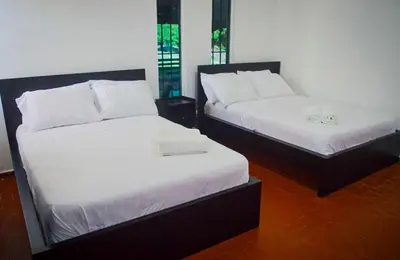 two beds in a room with white sheets at Villa moderna 95 in San José de Las Matas