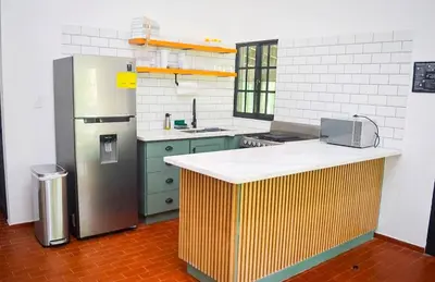 a kitchen with a refrigerator and a counter in it at Villa moderna 95 in San José de Las Matas