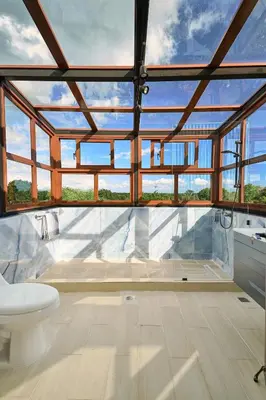 a bathroom with a white toilet and some windows at Villa La Chiquita Paradise Pool and BBQ in Baní