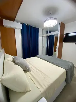 a bedroom with a bed and a blue curtain at Modern, Unique And Stylish 1 Bedroom Apartment in San Pedro de Macorís