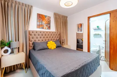 a bedroom with a bed and a bathroom at Chic Urban Retreat with Pool, Gym, & Free Parking in Santiago de los Caballeros