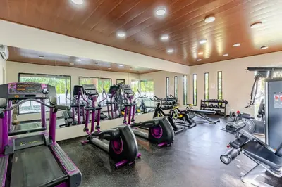 a gym with a bunch of treadmills and machines at Chic Urban Retreat with Pool, Gym, & Free Parking in Santiago de los Caballeros