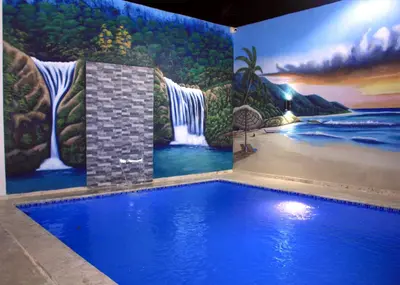 a swimming pool with a mural of a waterfall at RGgrup in Pantoja