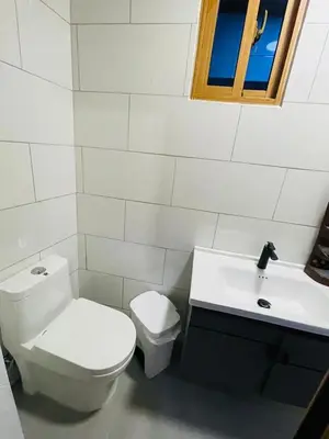 a white bathroom with a toilet and a sink at Villa Estela Jarabacoa in Jarabacoa