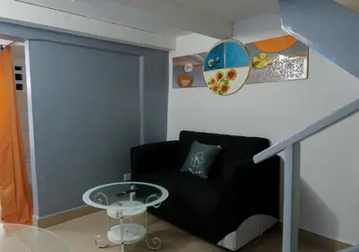 a living room with a black couch and a table at Casa Ballenas2 in Las Terrenas