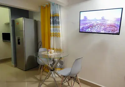 a dining room with a table and a television on the wall at Casa Ballenas2 in Las Terrenas