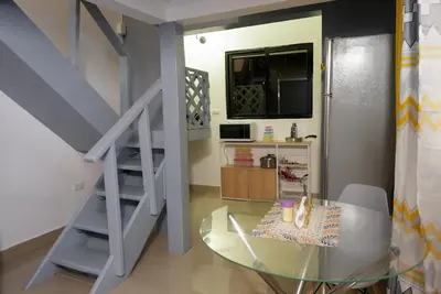 a dining room with a glass table and a staircase at Casa Ballenas2 in Las Terrenas