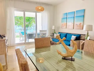 a living room with a glass table and a blue couch at Escape-Fortunity 1 in San Felipe de Puerto Plata