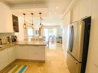 a kitchen with white cabinets and a stainless steel refrigerator at Escape-Fortunity 1 in San Felipe de Puerto Plata