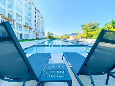 a couple of chairs sitting next to a swimming pool at Escape-Fortunity 1 in San Felipe de Puerto Plata