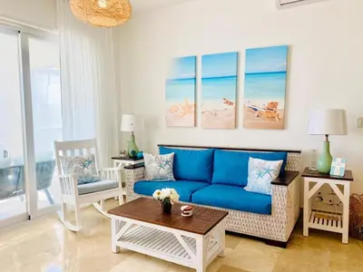 a living room with a blue couch and a table at Escape-Fortunity 1 in San Felipe de Puerto Plata