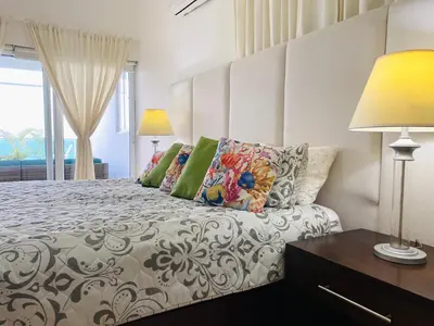 a bedroom with a bed and two lamps and a window at Bluegreen Oceanfront Condo at Laguna Beach in Sosúa