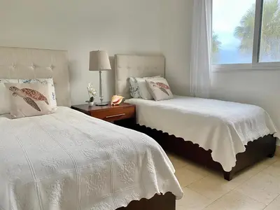 a bedroom with two beds and a window at Bluegreen Oceanfront Condo at Laguna Beach in Sosúa