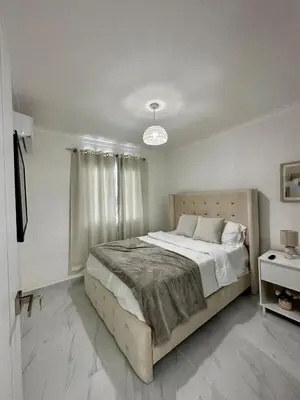 a bedroom with a large bed in a white room at Santo Domingo Este Stylish Condo in San Isidro