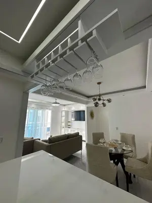 a kitchen and living room with a table and chairs at Santo Domingo Este Stylish Condo in San Isidro