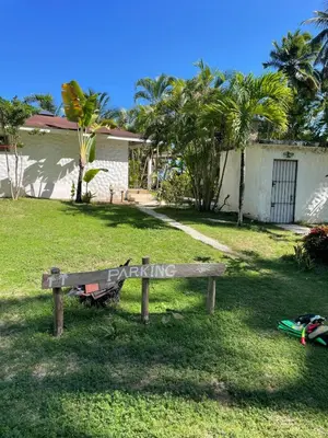 a wooden bench sitting in the grass in a yard at Villa Bianca - BEACHFRONT with Pool in Sosúa
