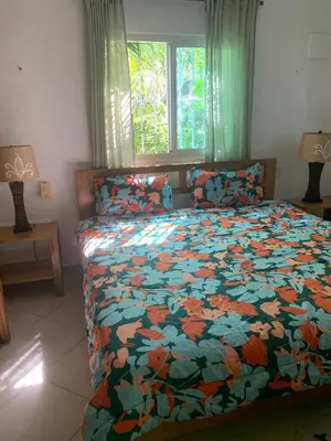 a bedroom with a bed with a floral comforter at Gorgeous apartment steps to Playa Punta Popy in Las Terrenas
