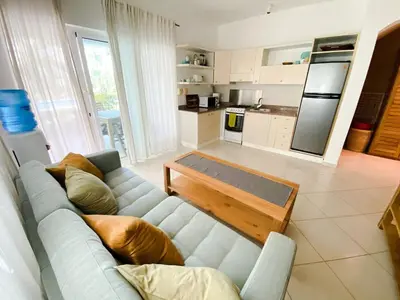 a living room with a blue couch and a kitchen at Gorgeous apartment steps to Playa Punta Popy in Las Terrenas