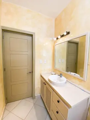 a bathroom with a sink and a mirror and a door at Gorgeous apartment steps to Playa Punta Popy in Las Terrenas