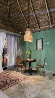 a dining room with a table and chairs and a chandelier at Boho villas and spa in El Valle