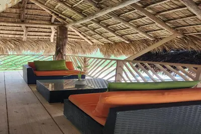 a living room with couches and a straw roof at Boho villas and spa in El Valle