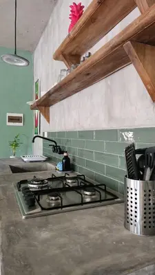 a kitchen with a stove and a green wall at Boho villas and spa in El Valle