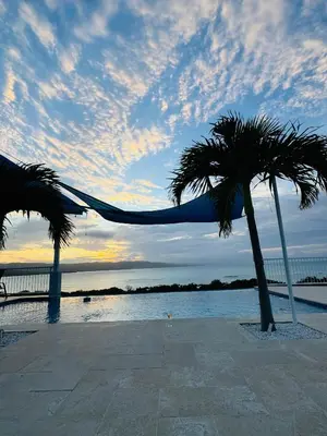 two palm trees in front of the water at sunset at Sundown Relaxed in Punta Rucia